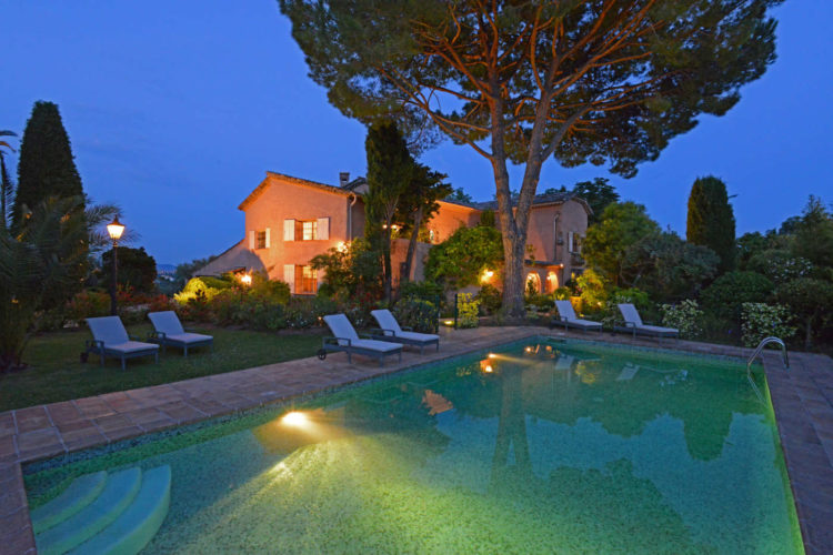 La piscine éclairée la nuit avec vue sur le village illuminé de Saint-Paul de Vence